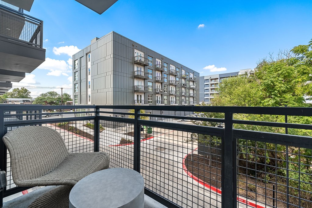 furnished balcony with two chairs and a view of a building