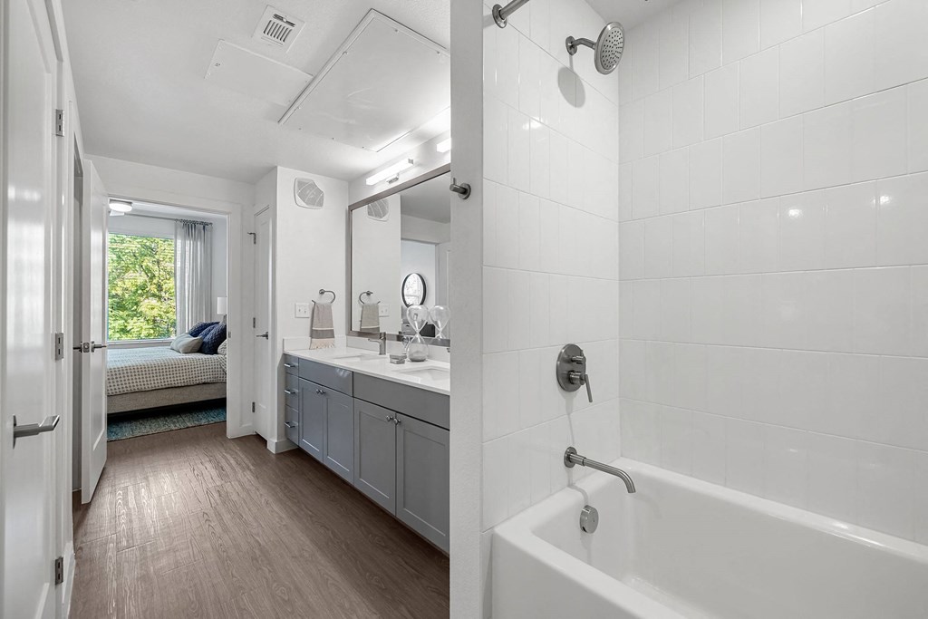 a bathroom with a tub and a sink and a mirror