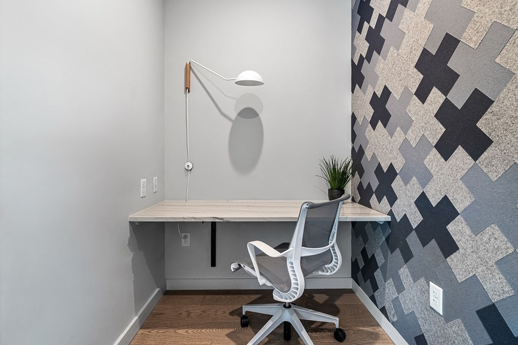 a desk with a chair in a room with a geometric wallpaper