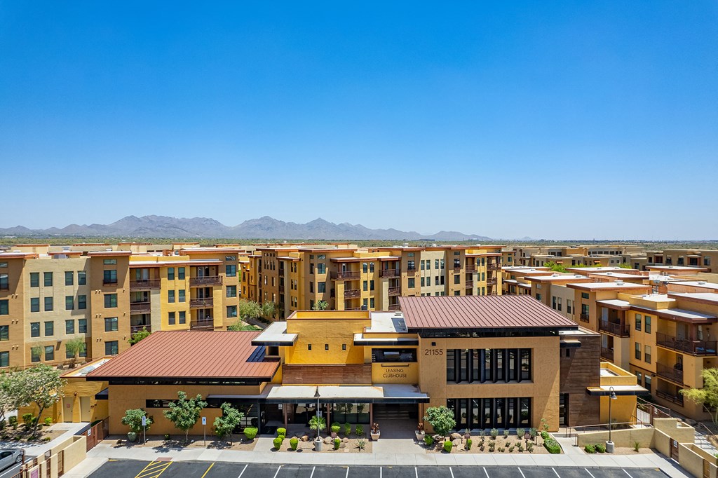 an aerial view of an apartment complex with buildings and mountains in the background