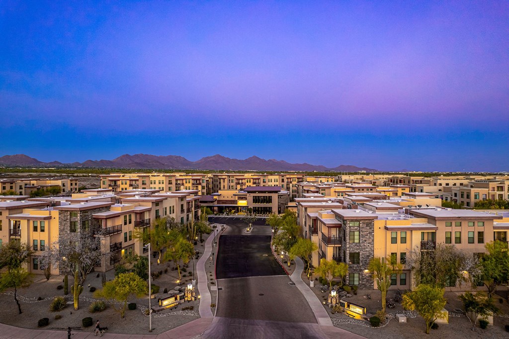 an aerial view of an apartment complex in the desert at dusk