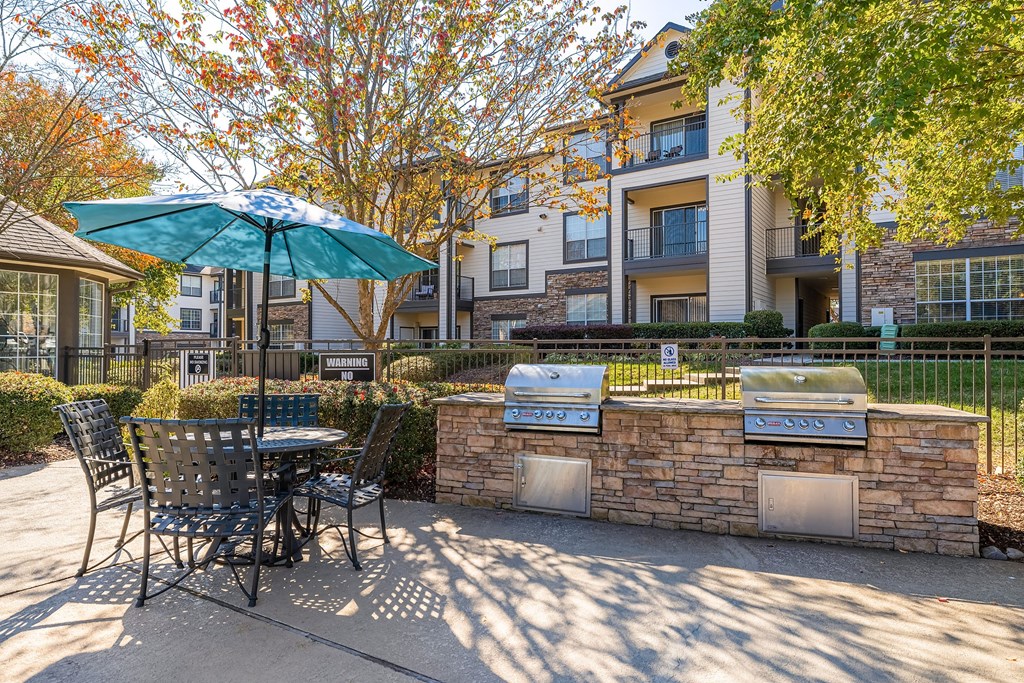 a patio with an umbrella and a table with chairs