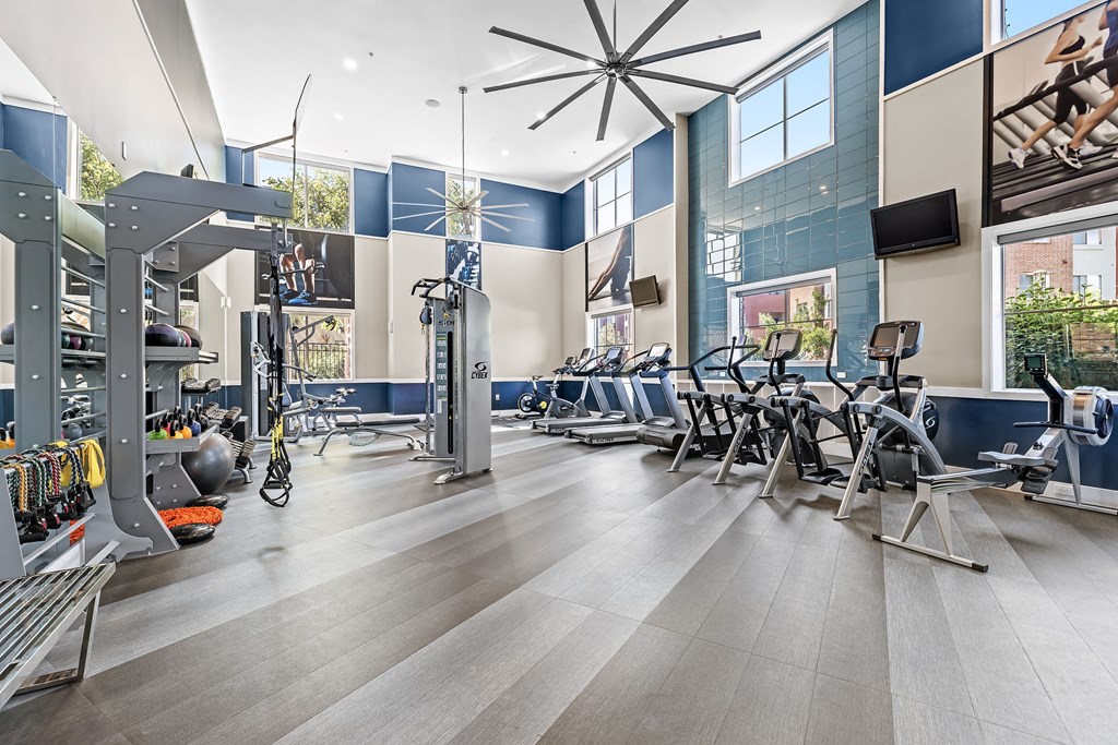 a gym with weights and cardio equipment at the district at highland village apartments