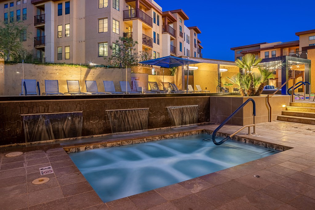 a swimming pool at night at an apartment complex