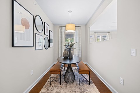 A dining room with a round table and chairs.