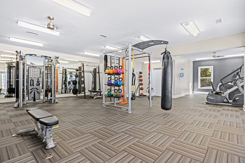 A gym with a variety of equipment including a punching bag.