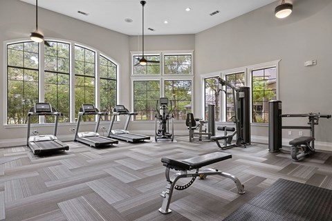 A gym with treadmills, weights, and exercise equipment.