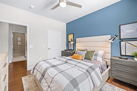 A bedroom with a bed, nightstand, and a ceiling fan.