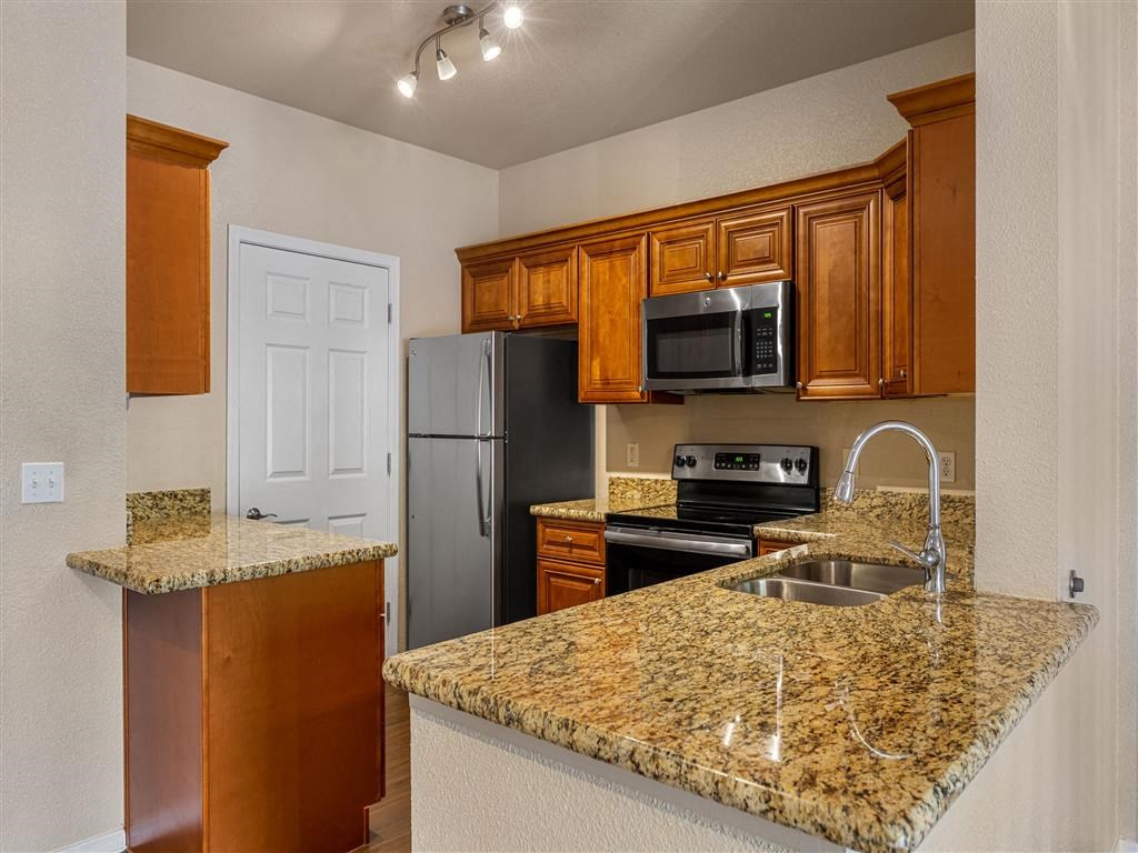 a kitchen with granite counter tops and a refrigerator