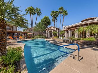 a large swimming pool with palm trees in front of a house