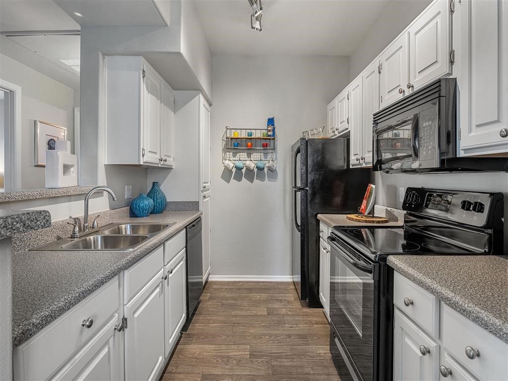 a kitchen with black appliances and white cabinets