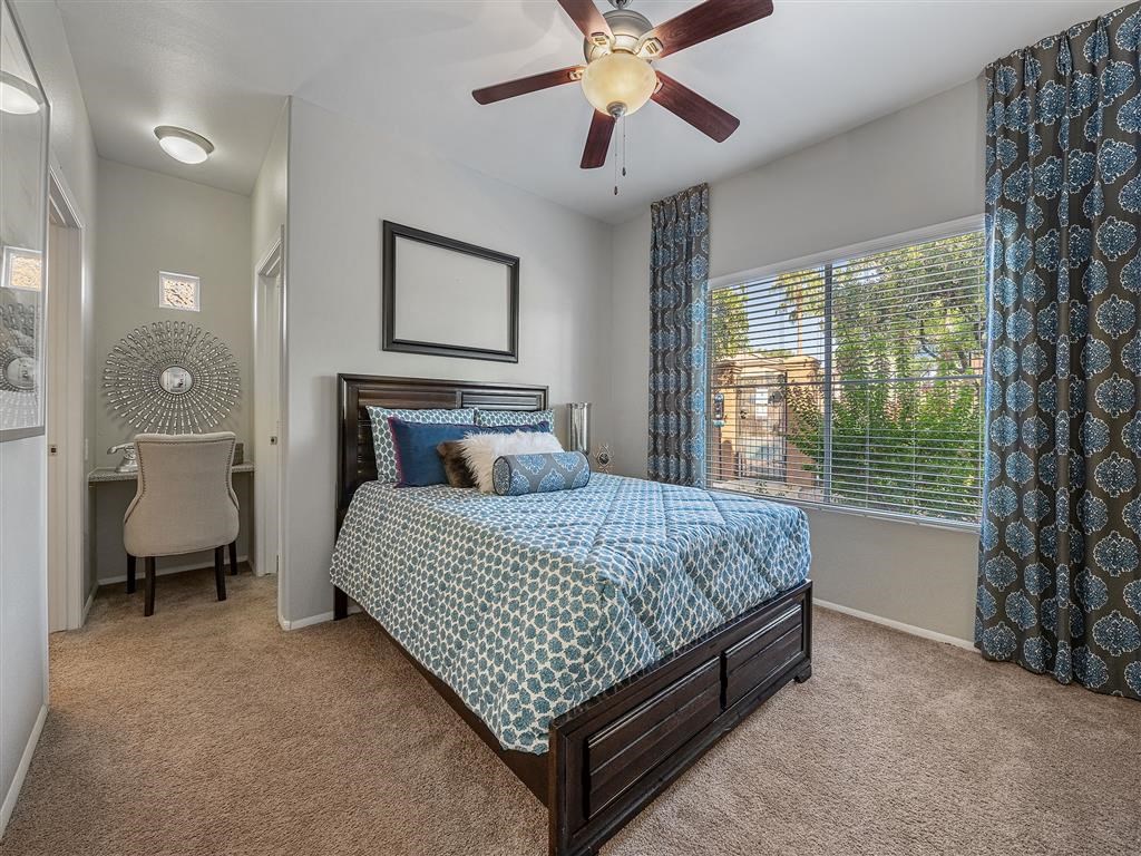 a bedroom with a bed and a ceiling fan