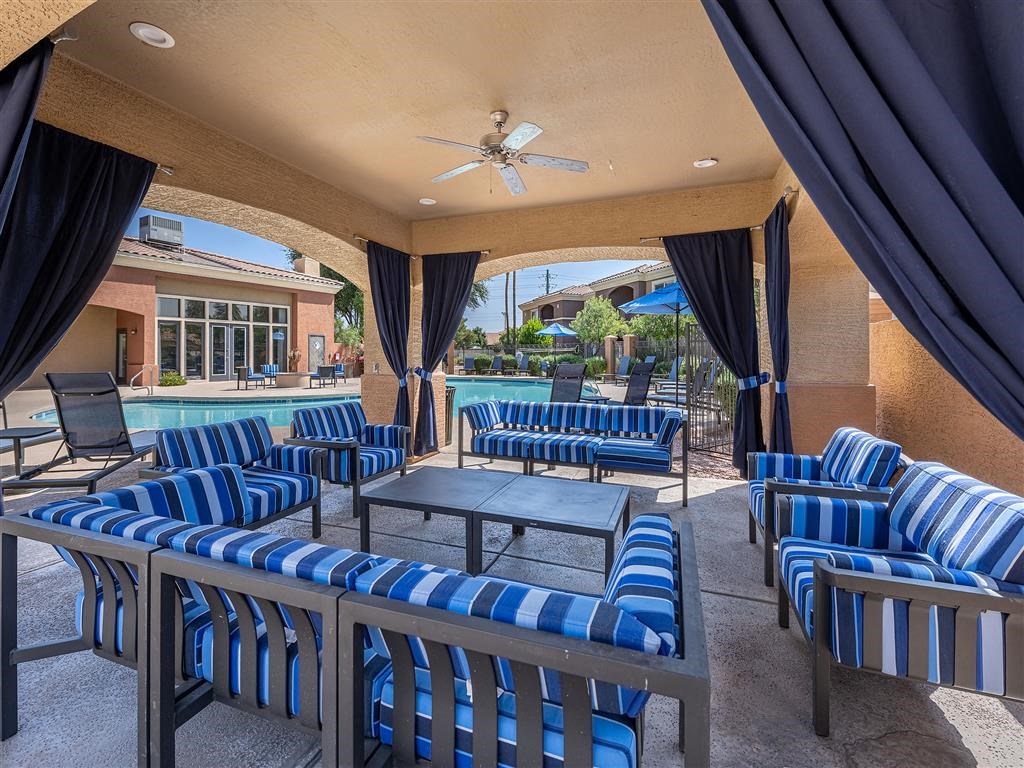 a patio with chairs and tables and a pool