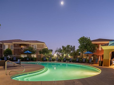 a swimming pool at night with a building in the background