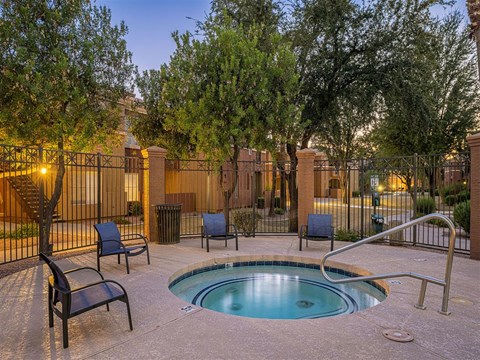 a swimming pool with chairs and trees in a courtyard