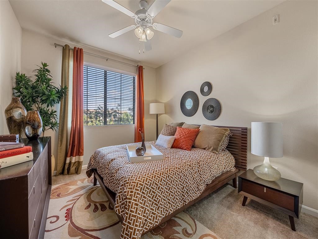 a bedroom with a bed and a ceiling fan