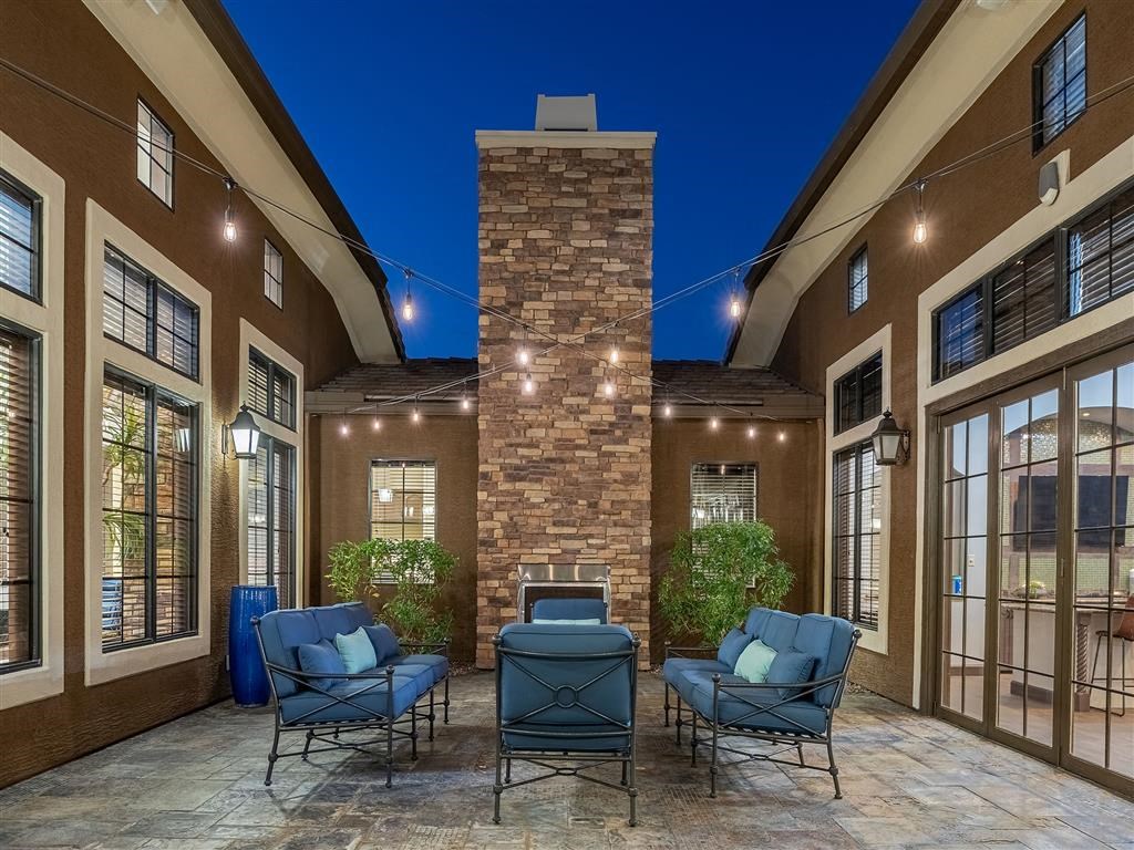 a patio area with chairs and a fireplace