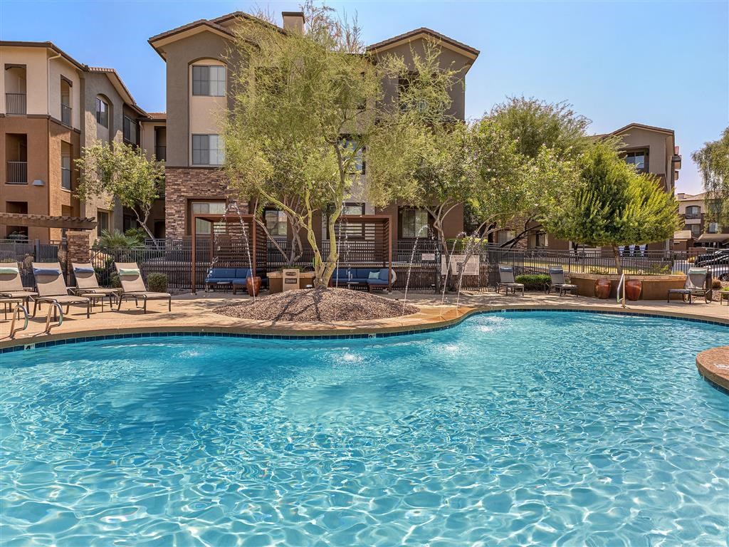 our apartments have a large swimming pool with chairs and trees