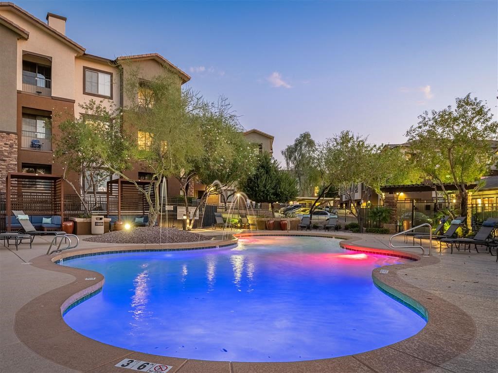 a resort style pool is lit up at night