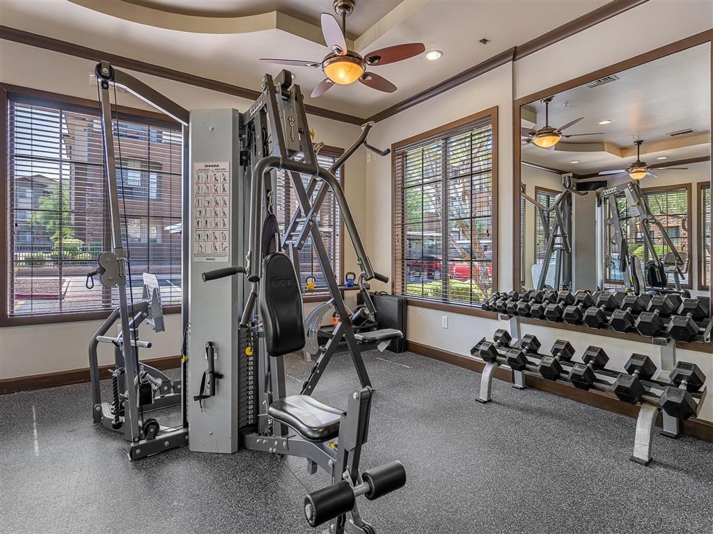 a gym with weights and a ceiling fan