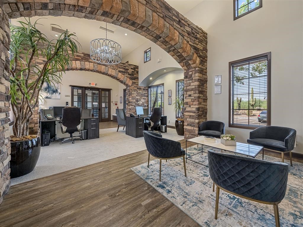 the lobby of a building with chairs and a table