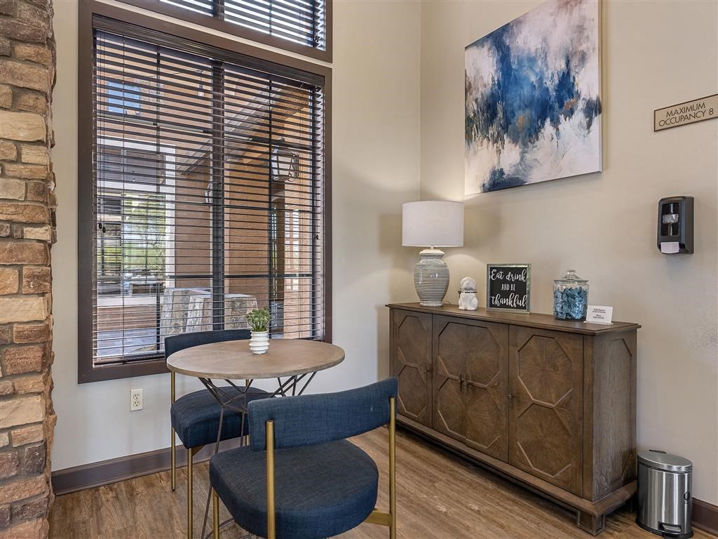 a living room with a table and chairs and a window