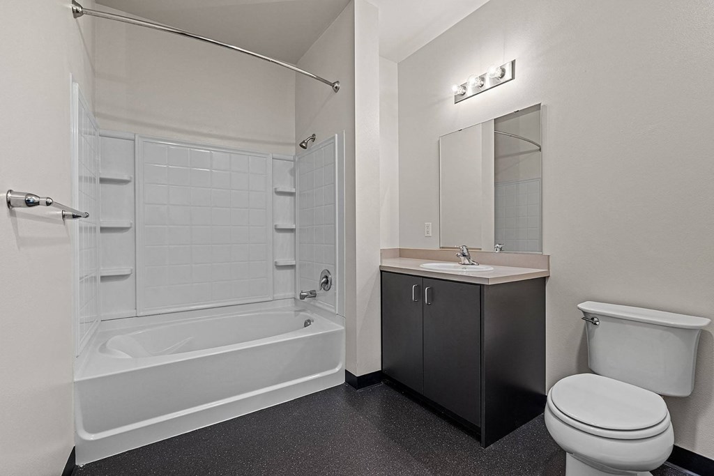 a bathroom with a toilet sink and tub and a mirror