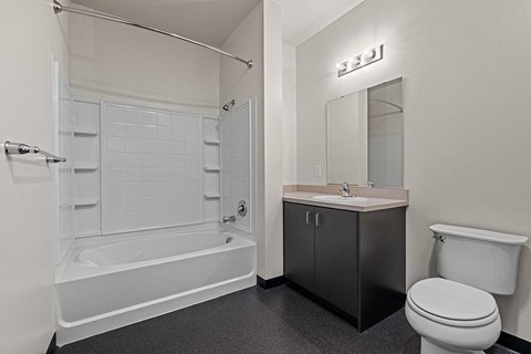 a bathroom with a toilet sink and tub and a mirror