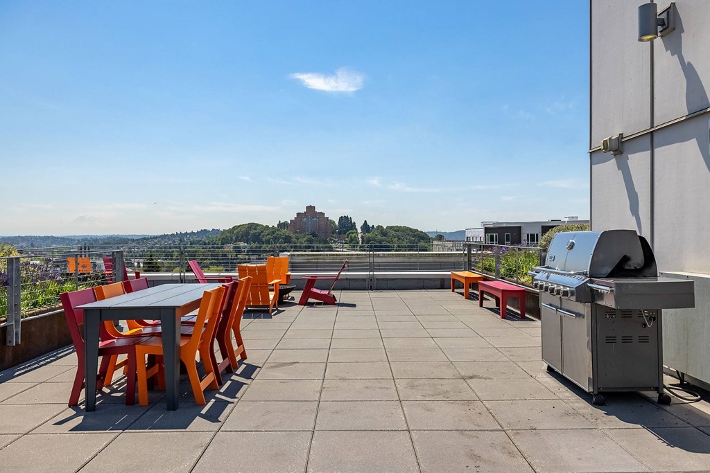 a patio with tables and chairs and a grill on a roof