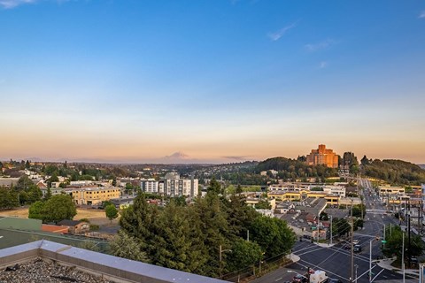 an aerial view of the city at sunset with mountains in the distance