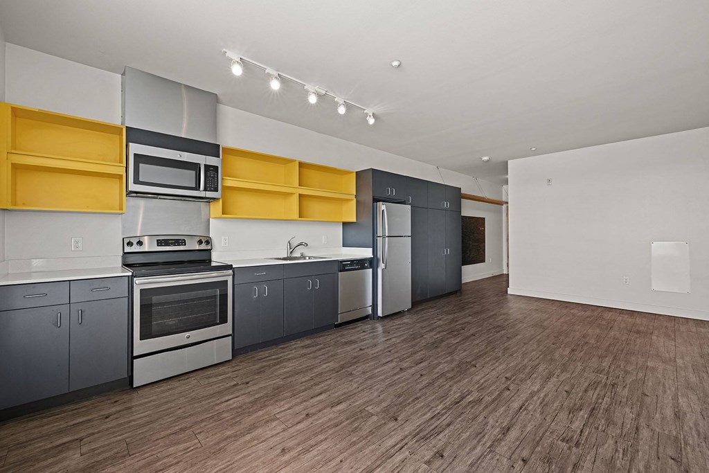 a kitchen with stainless steel appliances and yellow cabinets