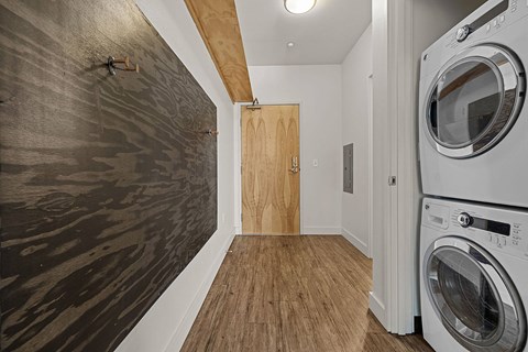 a washer and dryer in a laundry room with a wooden wall
