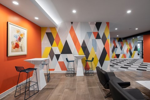 A modern dining area with a white table and black chairs.