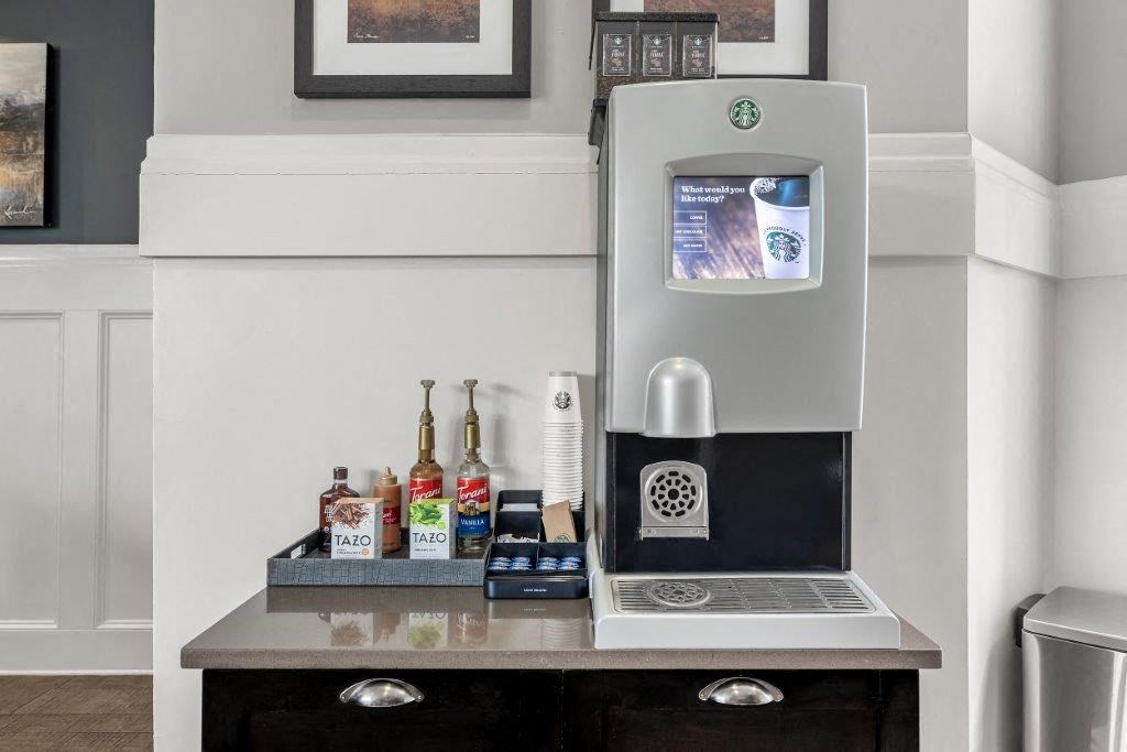 a small desk with a coffee machine and a laptop on it