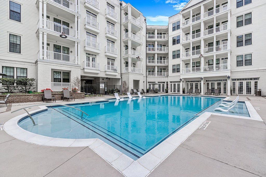 a swimming pool with an apartment building in the background