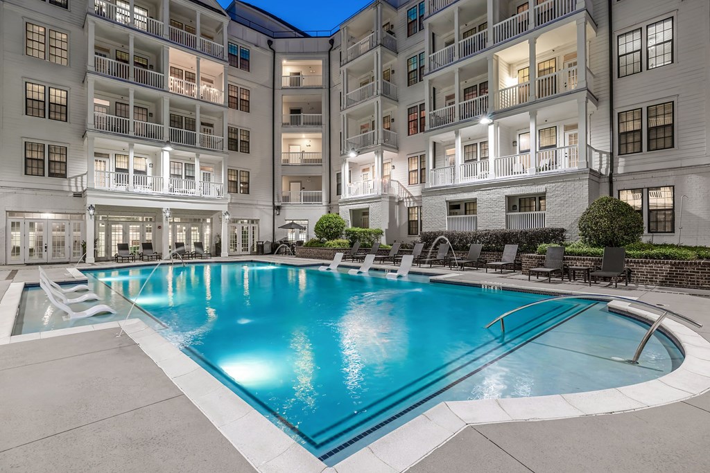 an apartment swimming pool in front of an apartment building