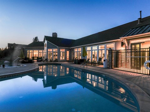A house with a pool in front of it.