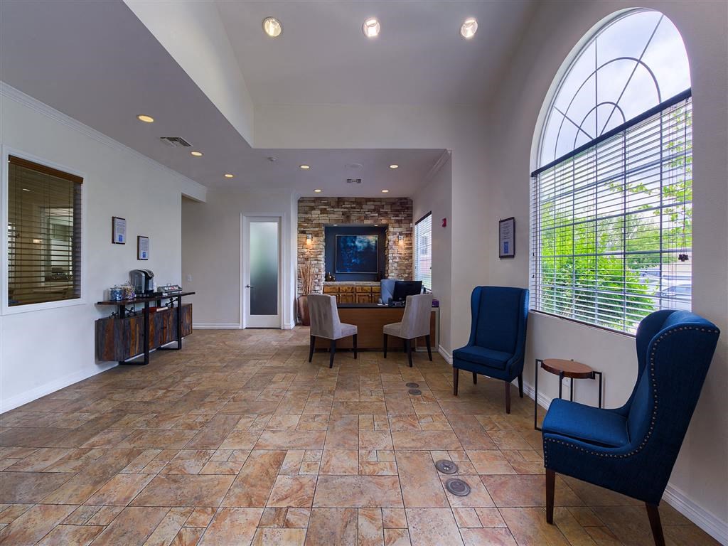 a lobby with a table and chairs and a large window