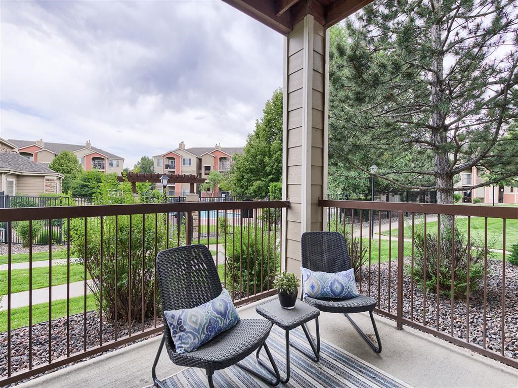 a patio with two chairs and a table on a balcony