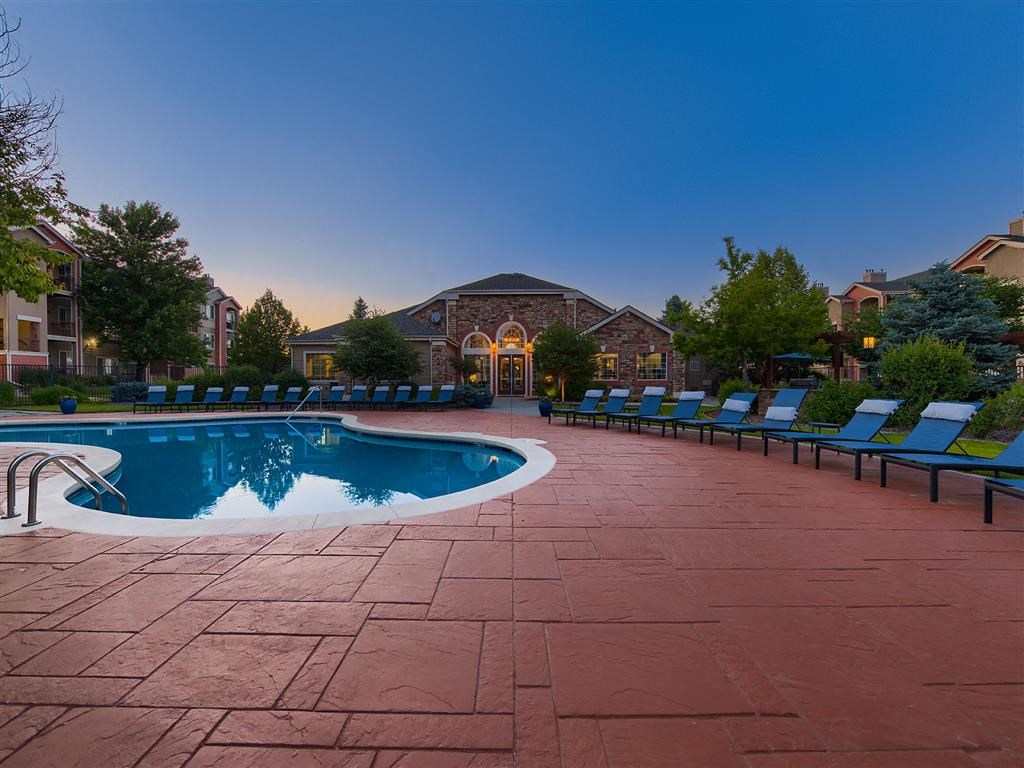 a swimming pool with blue lounge chairs around it