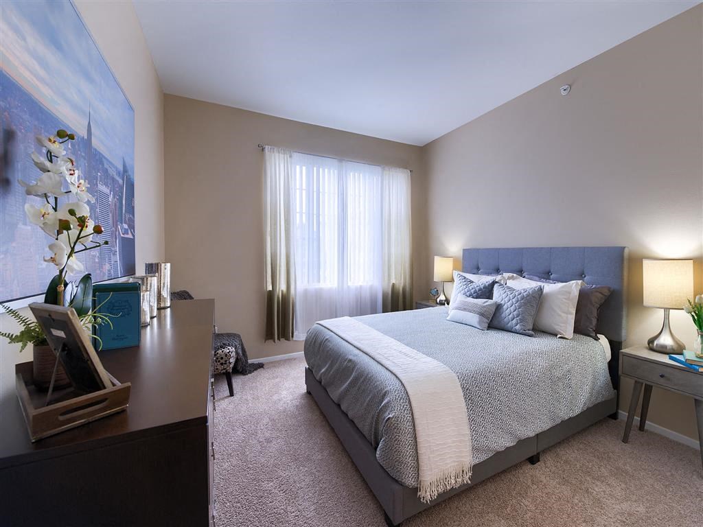 a bedroom with a bed and a dresser and a window