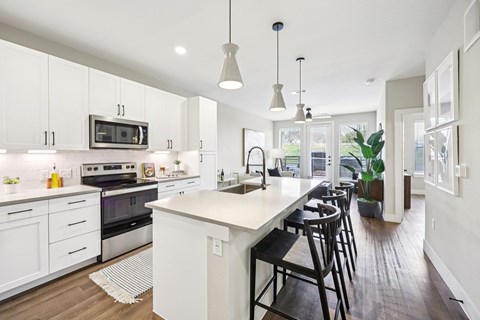 A modern kitchen with white cabinets and a large island.