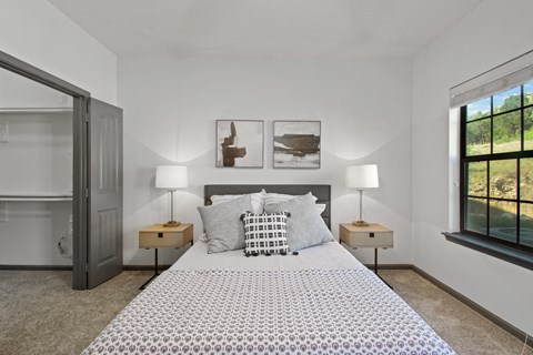 A bedroom with a large bed and two lamps.