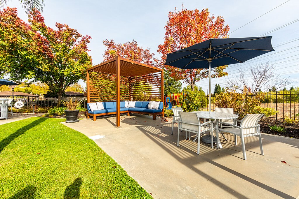 the backyard has a patio with a table and chairs and an umbrella