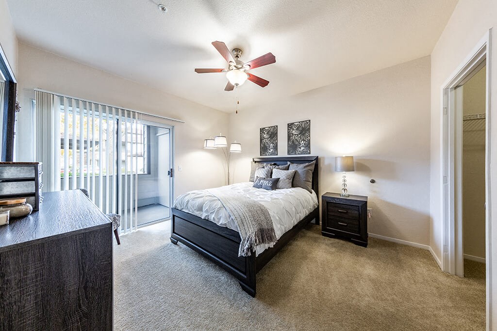 a bedroom with a bed and a ceiling fan