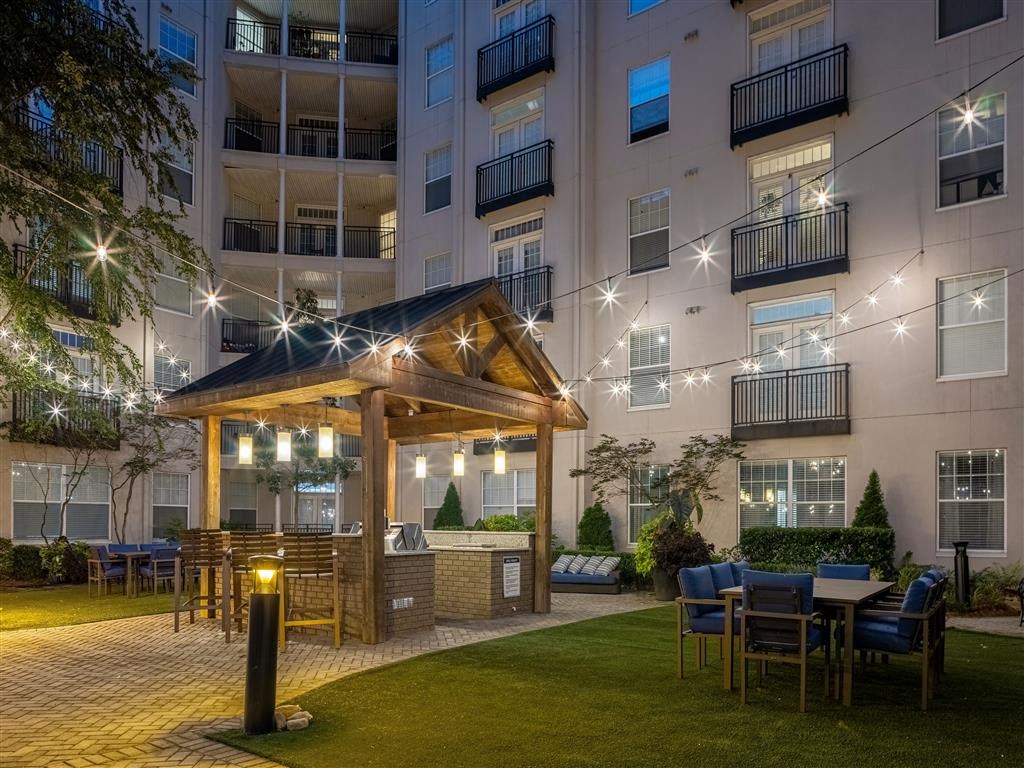 an outdoor area with tables and chairs in front of an apartment building