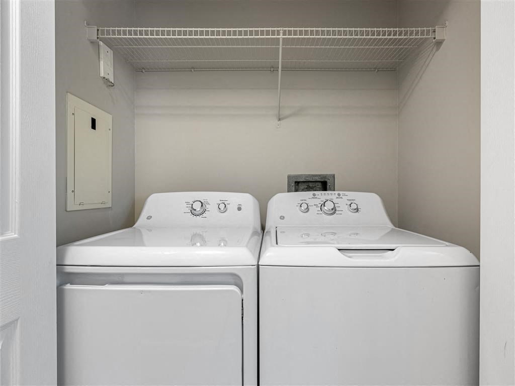 two white washers and dryers in a white laundry room