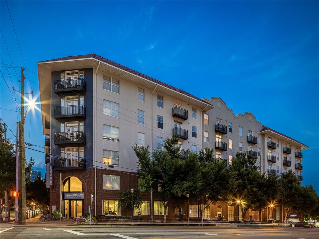 a large apartment building on a city street at night