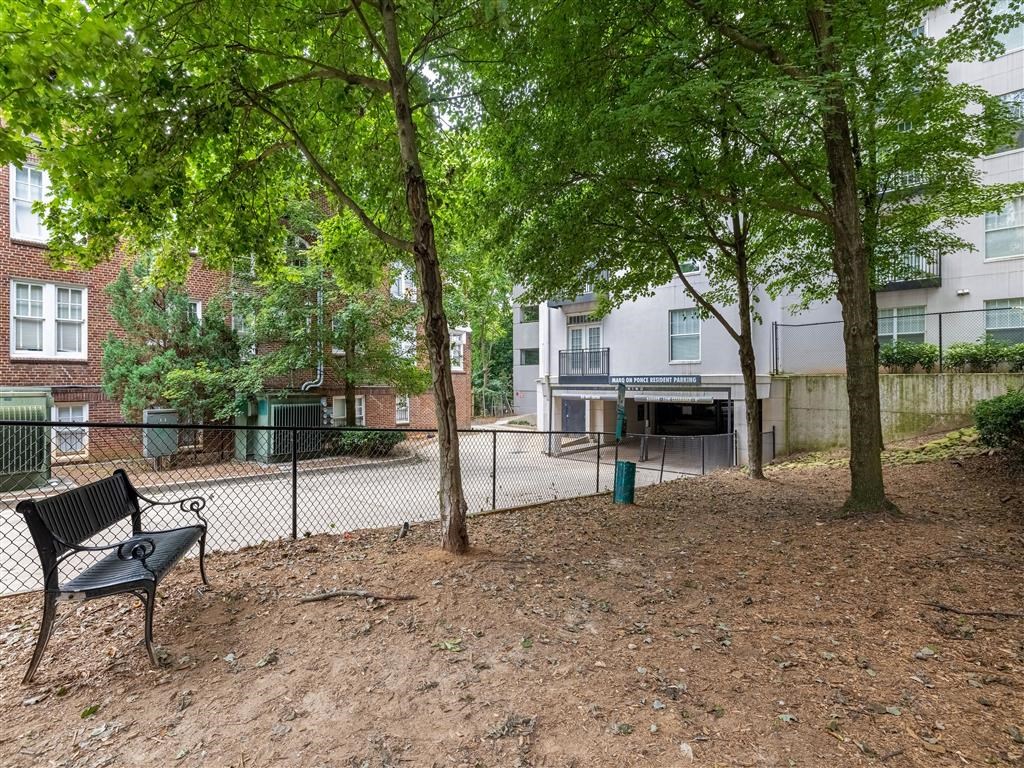 a park with a bench and trees in front of an apartment building