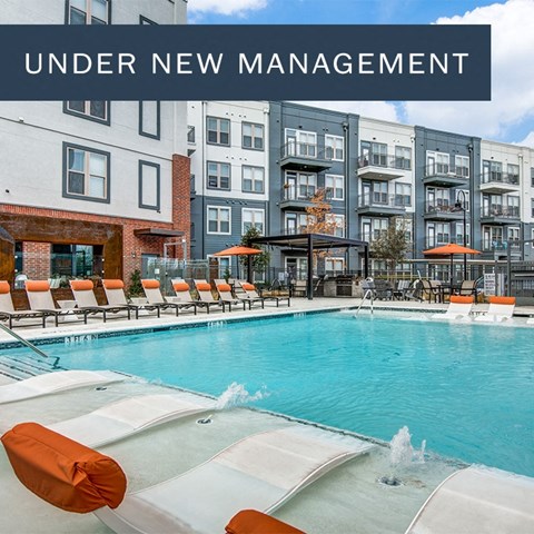 A pool with orange chairs and the words "Under new management" on the side.